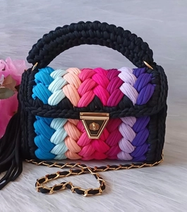 Detail der Regenbogen-Häkeltasche mit schwarzem Griff und goldenem Metalldreieckschloss