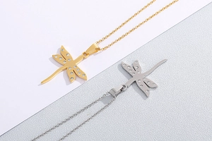 Detail of dragonfly pendant necklaces in gold and silver finish with sparkling rhinestones
