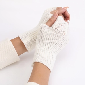 Close-up of white knit fingerless gloves showing delicate scale-like texture and soft yarn