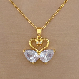 Detailed close-up of heart swan necklace pendant with teardrop-shaped zircon in gold finish