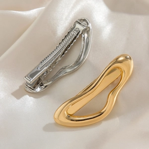Minimalist wavy metal hair clips in gold and silver finish with smooth mirror texture