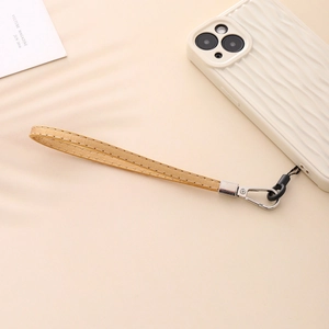 Detail of light brown PU leather phone wrist strap with white stitching and silver clasp