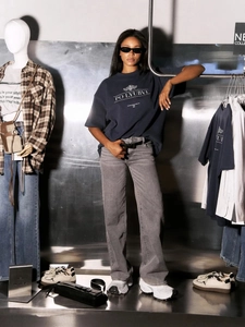 Detail of navy cotton T-shirt with letter print paired with washed grey denim jeans