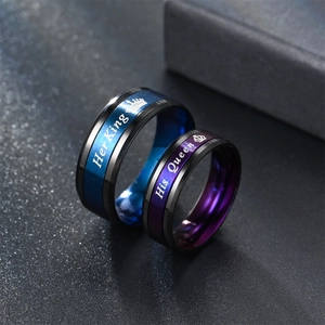 Close-up detail of couple stainless steel rings with Her King and His Queen laser engraved.