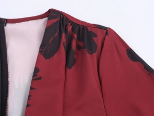 Detail eines weinroten Kleides mit Tintendruck, Falten an der Schulter und verdecktem Reißverschluss