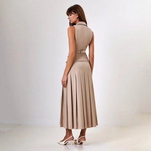 Vue arrière d'un ensemble chic beige avec gilet sans manches et jupe midi plissée