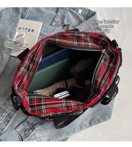 Detail showing the spacious interior of the red tartan tote bag with daily essentials