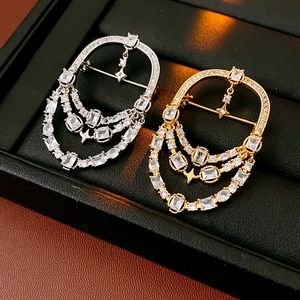 Détail de broches ovales plaquées or 18k avec glands en zircon et pendentifs étoile
