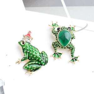 Detail of green enamel frog brooches with gold accents and sparkling rhinestones