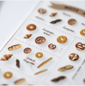 Macro shot of 3D crystal epoxy nail stickers featuring realistic European bread designs