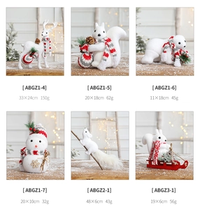 Detail view of plush Christmas reindeer and squirrel figurines with knitted scarves