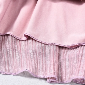 Détail de couture sur tissu rose et texture de maille plissée aux paillettes argentées