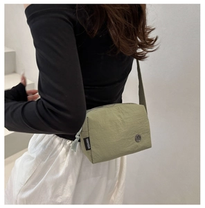 Olive green waterproof nylon crossbody square bag shown on model with casual embroidery style
