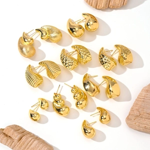 Detailed macro shot of diverse 14K gold plated earrings with shell and wave textures