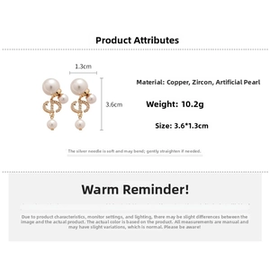 Macro view of gold-plated copper earrings with CD design, zircons and pearls