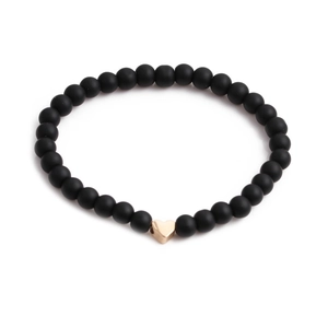 Minimalist matte black stone beaded bracelet with a polished gold heart-shaped charm