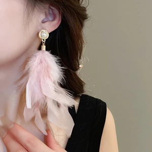 Close-up of elegant pink feather drop earrings with round pearl stud worn by model