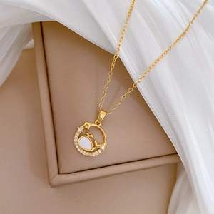 Elegant gold whale necklace with shell inlay and sparkly diamonds on a circular pendant