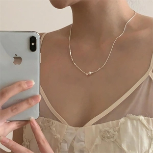 Detailed close-up of 925 sterling silver chain necklace with pearl and metal tube pendant
