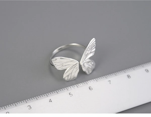 Detailed view of S925 silver butterfly ring with 2.5cm width measurement on ruler