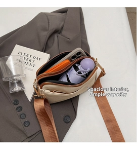 Detailed interior view of beige crossbody bag with two main pockets and wide strap