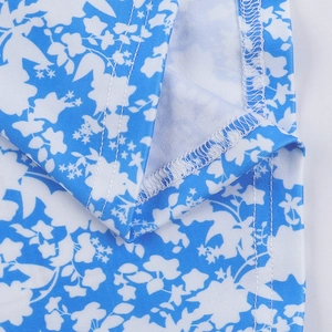 Close-up of precision stitching and blue floral print on the slim fit dress fabric