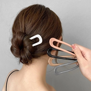 Minimalist U-shaped hair pins in multiple colors shown on a model for bun styling