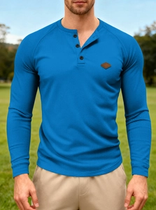 Detail of waffle knit fabric and button neckline on a blue long sleeve Henley shirt