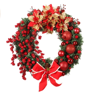 Christmas wreath with red berries, golden flowers and a large bow for front door decor