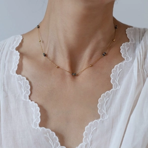 Set di collane in acciaio inossidabile con perline blu e oro indossato da una modella