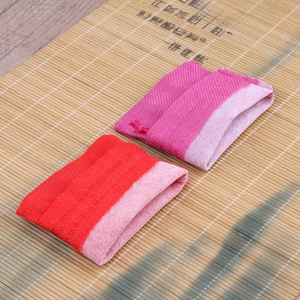 Linen drawstring jewelry pouches in red and rose red on a rustic bamboo background