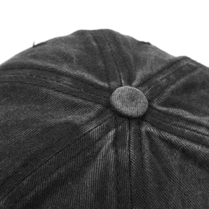 Close-up of the vintage washed corduroy fabric texture and top button on the black baseball cap
