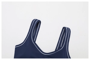 Close-up of dark blue yoga bra with white zig-zag stitching on wide shoulder straps
