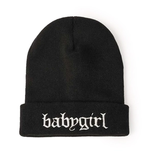 Detailed close-up of white gothic babygirl embroidery on black knitted beanie hat