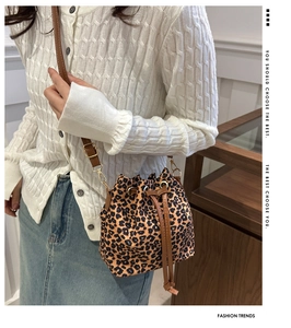 Detail of leopard print bucket bag with leather drawstring and gold metal hardware