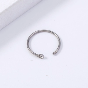 Detail of silver stainless steel U-shaped nose ring with clear zircon crystal and ball