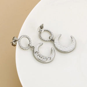 Detail of silver moon stud earrings with sparkling rhinestones and hammered texture