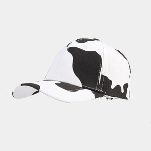 Detail view of the classic black and white cow print pattern on a cotton canvas baseball cap