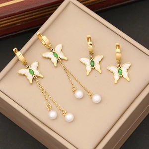 Elegant gold butterfly earrings set with white shell, green stones and pearl tassels