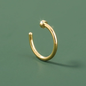Minimalist golden C-shaped stainless steel nose ring with a polished metallic finish