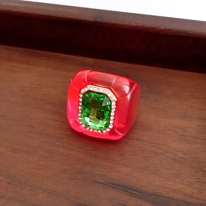 Macro detail of a vintage resin ring with green gemstone and sparkling diamond accents