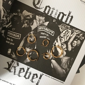 Detailed view of three pairs of golden stainless steel hoop earrings in various sizes
