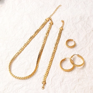 Flat lay of gold snake chain jewelry set including necklace, bracelet, earrings and ring
