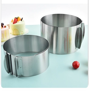 Close-up of adjustable stainless steel mousse ring with fruit cake on blue background