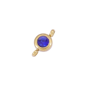 Detailed macro view of a 6.5mm gold stainless steel charm with deep blue birthstone