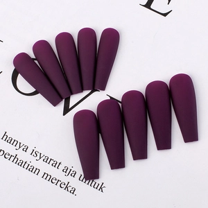 Detailed view of matte purple press-on nails in T-shape coffin style on white background