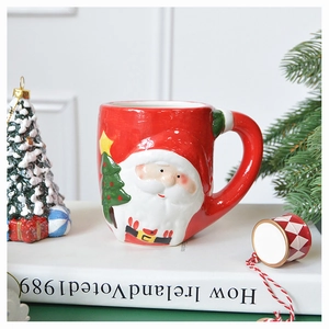 Detail of 3D Santa Claus relief on red ceramic mug with festive Christmas decorations