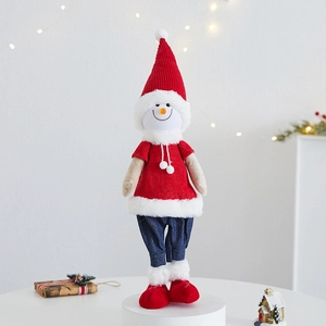 Plush Christmas snowman figurine in a red knit hat standing on a white pedestal