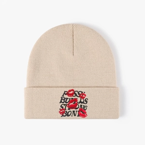 Beige knitted beanie with black slogan embroidery and red lip patterns in street style