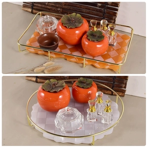 Detail of rectangular and round checkered trays with elegant golden metal handles